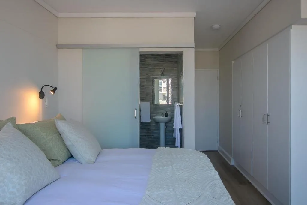 Modern bedroom with queen bed, ensuite bathroom, and built-in wardrobes