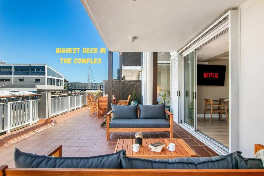 Spacious wooden deck with outdoor seating and view of Knysna waterfront