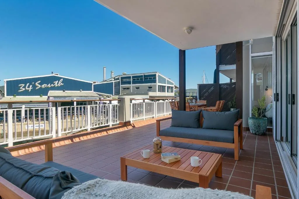 Waterfront deck with wooden furniture and scenic Knysna harbor views