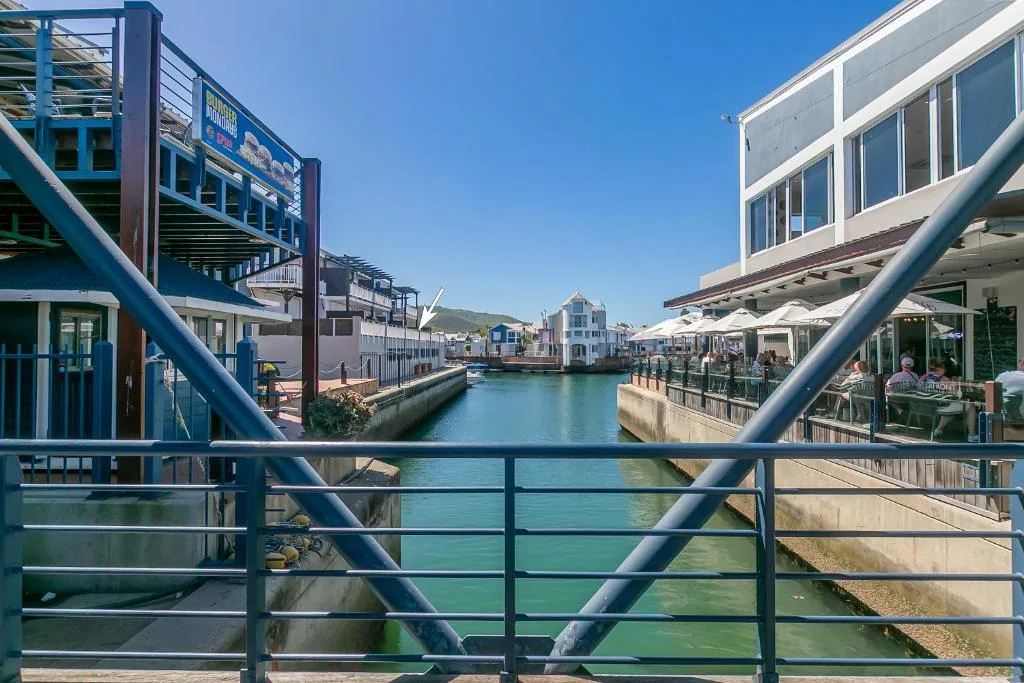 Scenic waterfront canal view with colorful buildings and mountains beyond