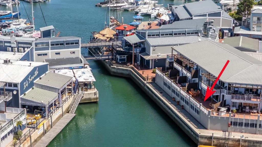 Waterfront marina with boats, turquoise water, and scenic harbor views