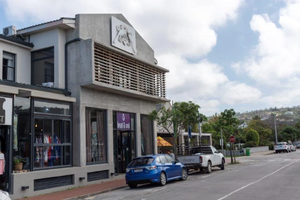 Modern apartment building exterior with retail storefronts and street parking