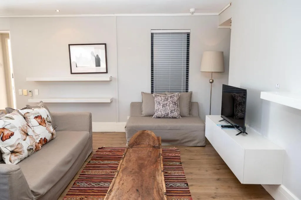 Modern lounge with gray sofas, TV, and minimalist wall decor