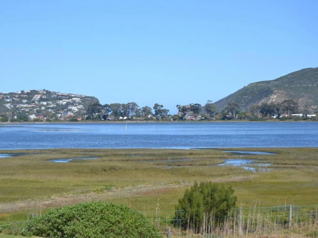 Scenic lagoon view with mountains, vegetation, and waterfront homes