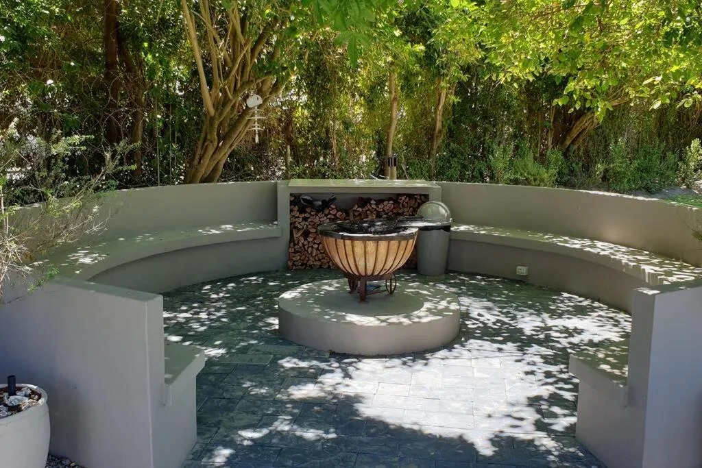 Shaded outdoor patio with built-in seating and central fire pit