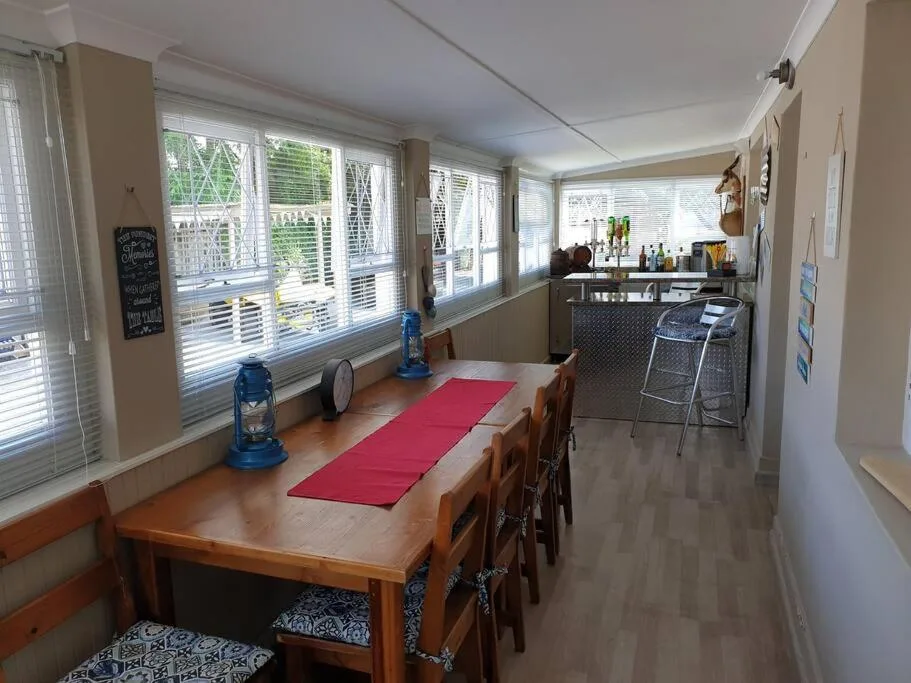 Spacious dining area with wooden table and large windows overlooking garden