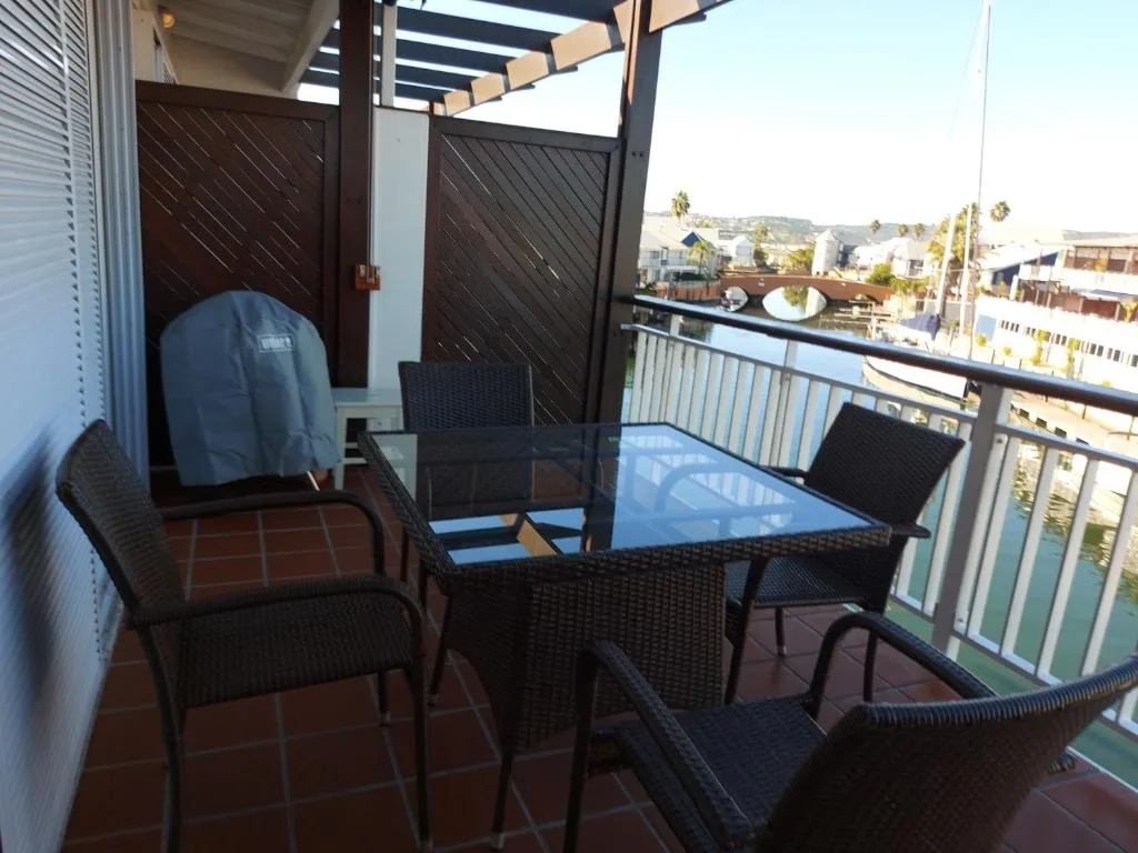 Shaded outdoor balcony with seating overlooking Knysna town and waterfront