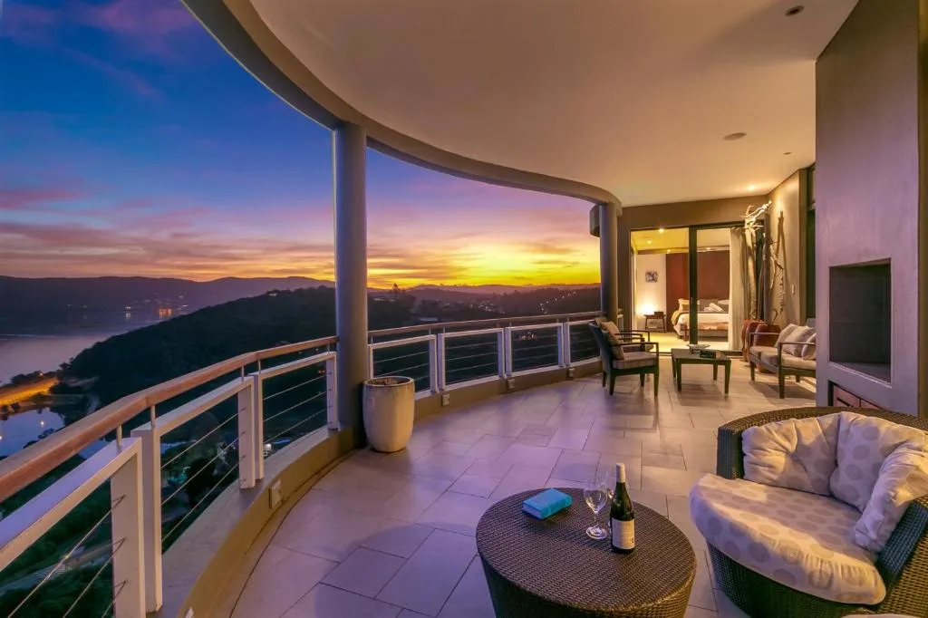 Sunset over lagoon and mountains from expansive curved deck with seating