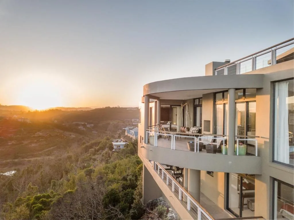 Sunset landscape over forested valleys and distant mountains from elevated property