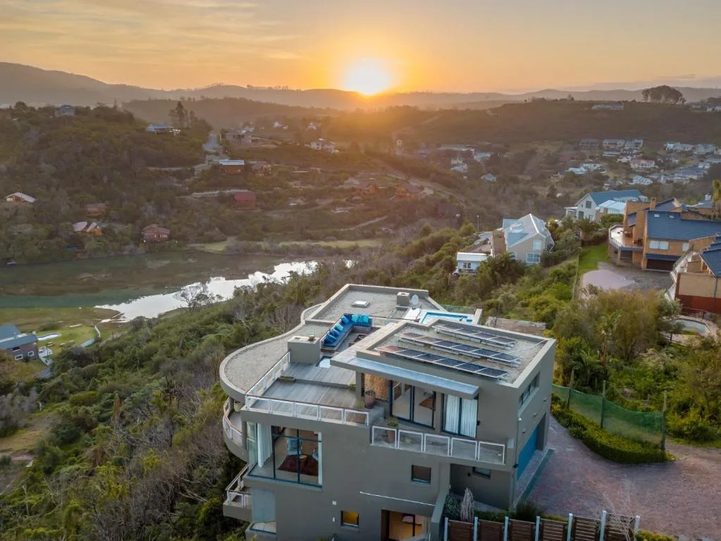 Sunrise over Knysna lagoon with surrounding hills and scattered homes