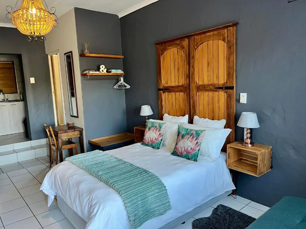 Spacious bedroom with queen bed, wooden wardrobe, and dark accent wall