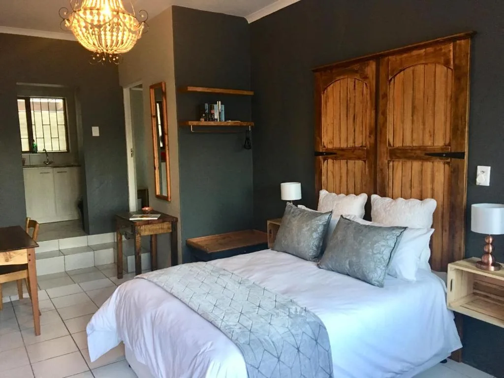 Spacious bedroom with queen bed, wooden wardrobe, and dark teal accent walls