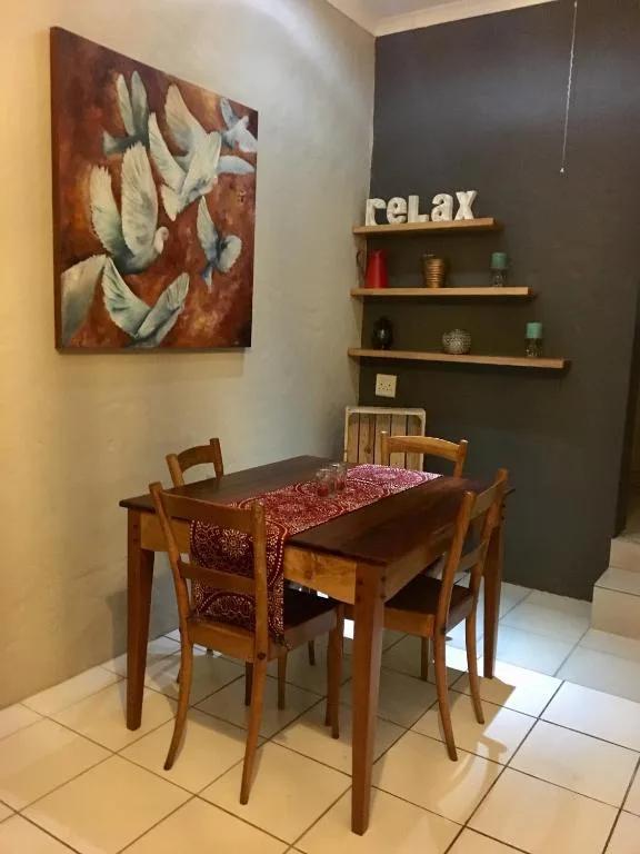 Wooden dining table with four chairs and red table runner