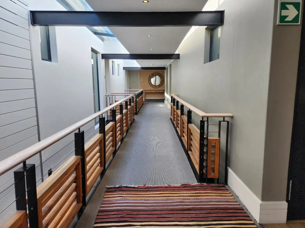 Modern hallway with wooden railings and skylight windows above