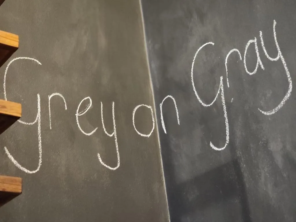 Chalkboard with handwritten text reading 'spread joy' in white chalk