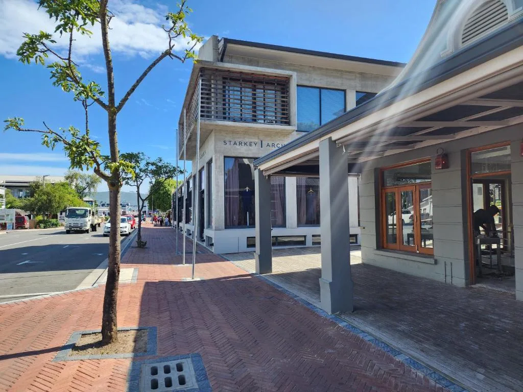 Modern building facade with covered entrance and streetfront patio area