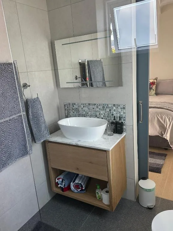 Modern bathroom with white vessel sink and wooden vanity unit