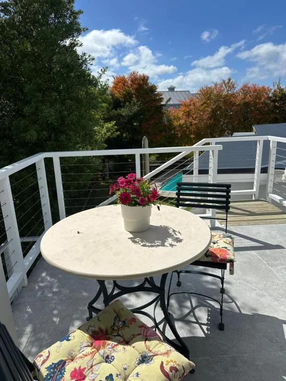 Outdoor deck with round table, flowering plant, and mountain views