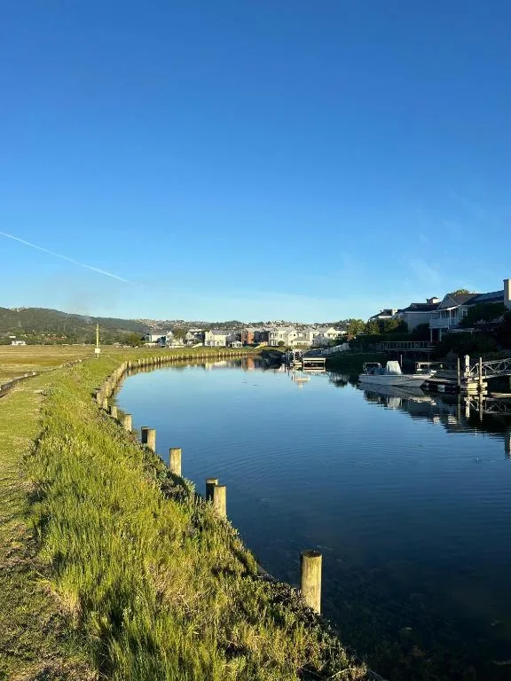 Calm lagoon waterfront with mountain backdrop and riverside homes