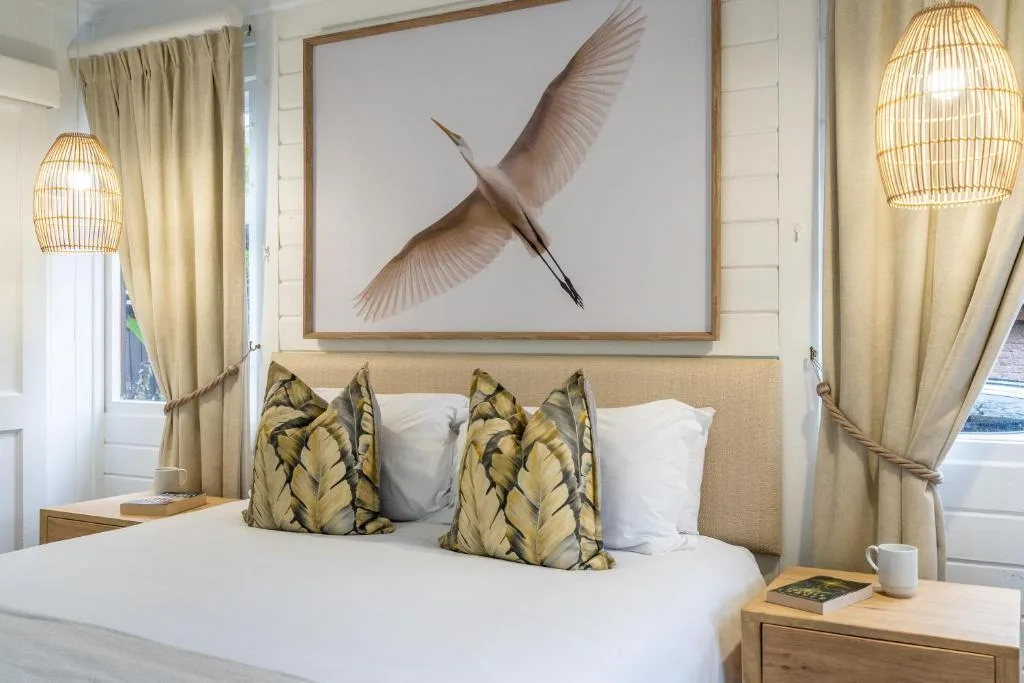 Elegant bedroom with queen bed, patterned cushions, and flying heron artwork