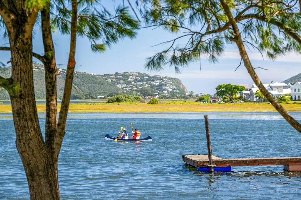 Lagoon view with kayakers, mountains, and waterfront homes visible