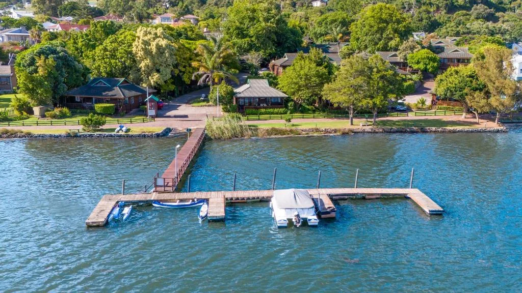 Waterfront property with private jetty and moored boats on lagoon