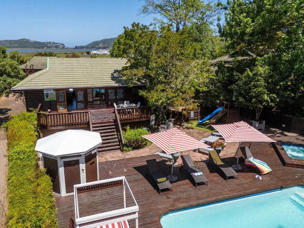 Wooden deck with loungers, umbrellas, and lagoon views beyond