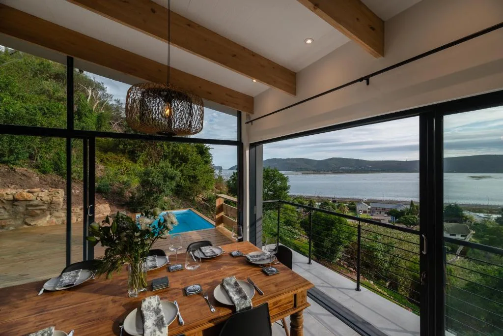 Elevated deck with dining table overlooking Knysna Lagoon and mountains