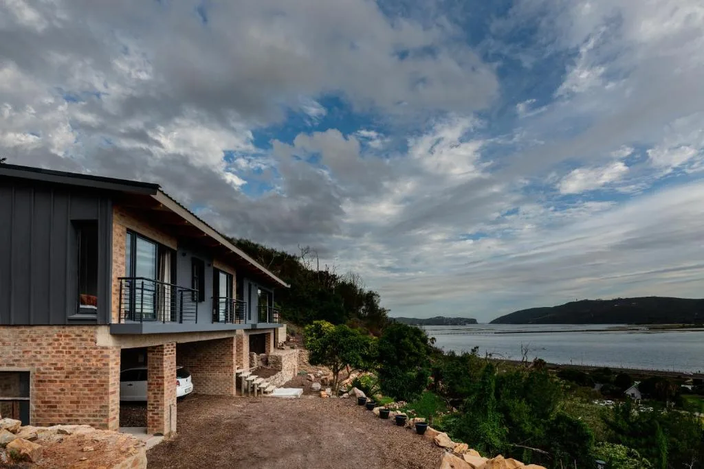 Modern brick villa with lagoon views, nestled on landscaped hillside overlooking water