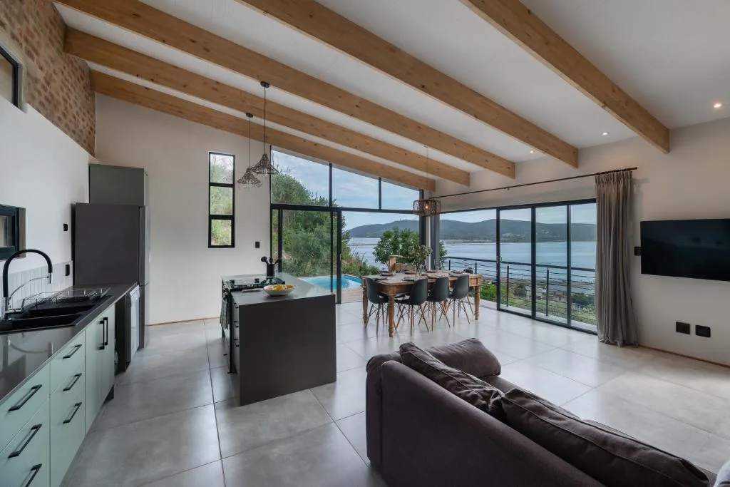 Modern lounge with sofa overlooking lagoon through large windows