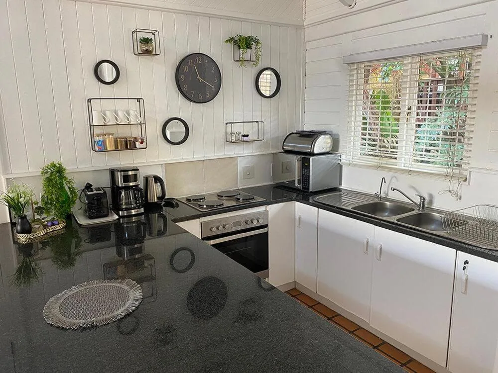 Modern kitchen with black countertops, white cabinetry, and stainless steel appliances