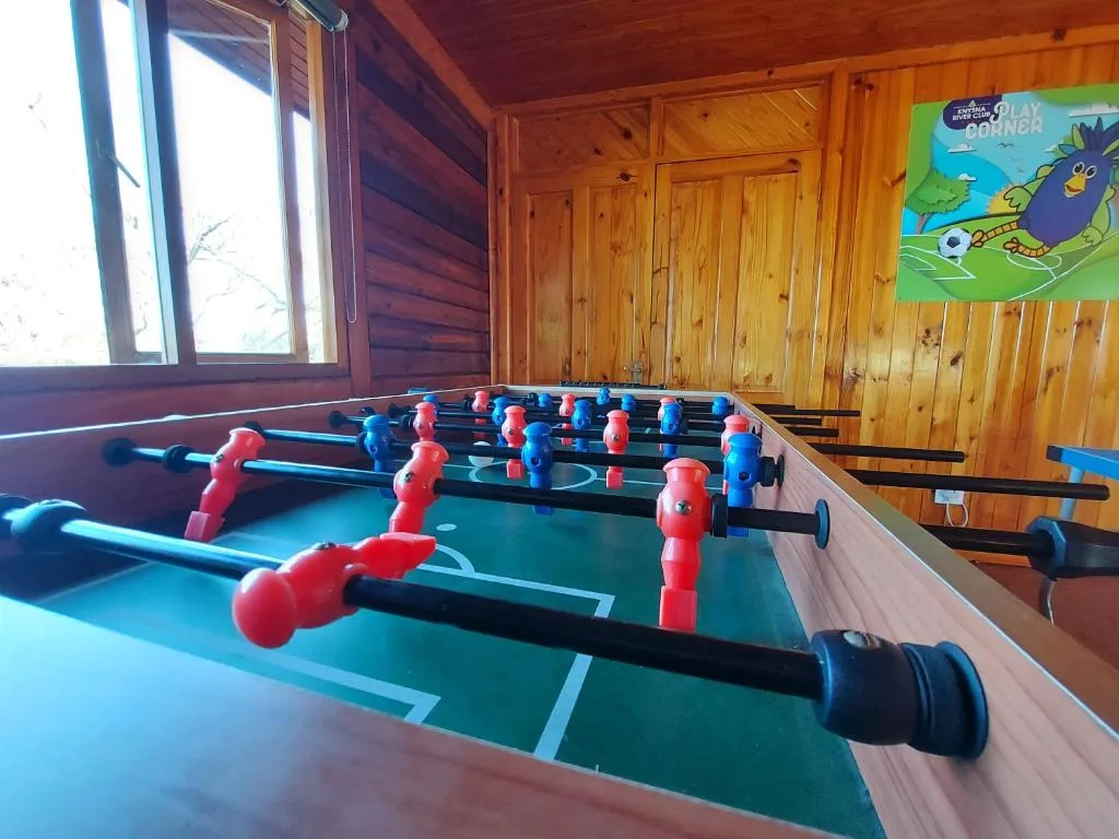 Foosball table with red and blue players in wooden games room
