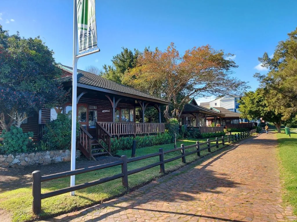 Charming wooden buildings with covered porches and black fencing lining brick pathway