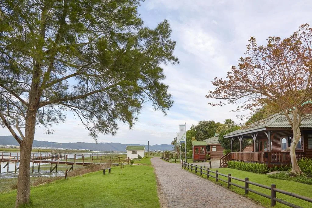 Rustic wooden cabins with manicured gardens overlooking Knysna River
