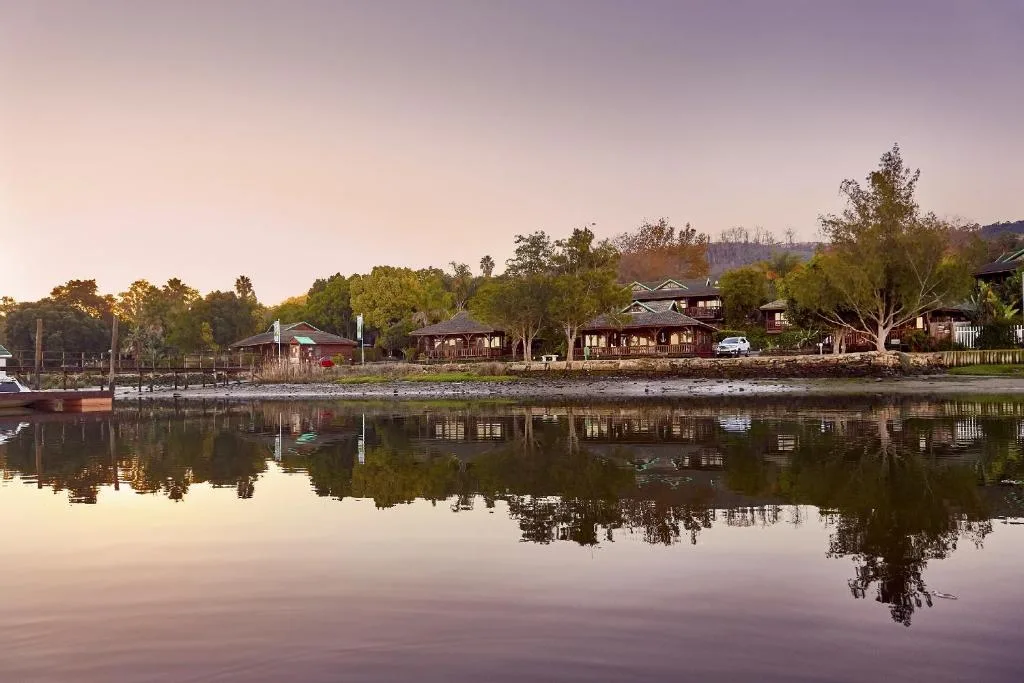 Serene river view with waterfront properties and lush trees reflected in calm water