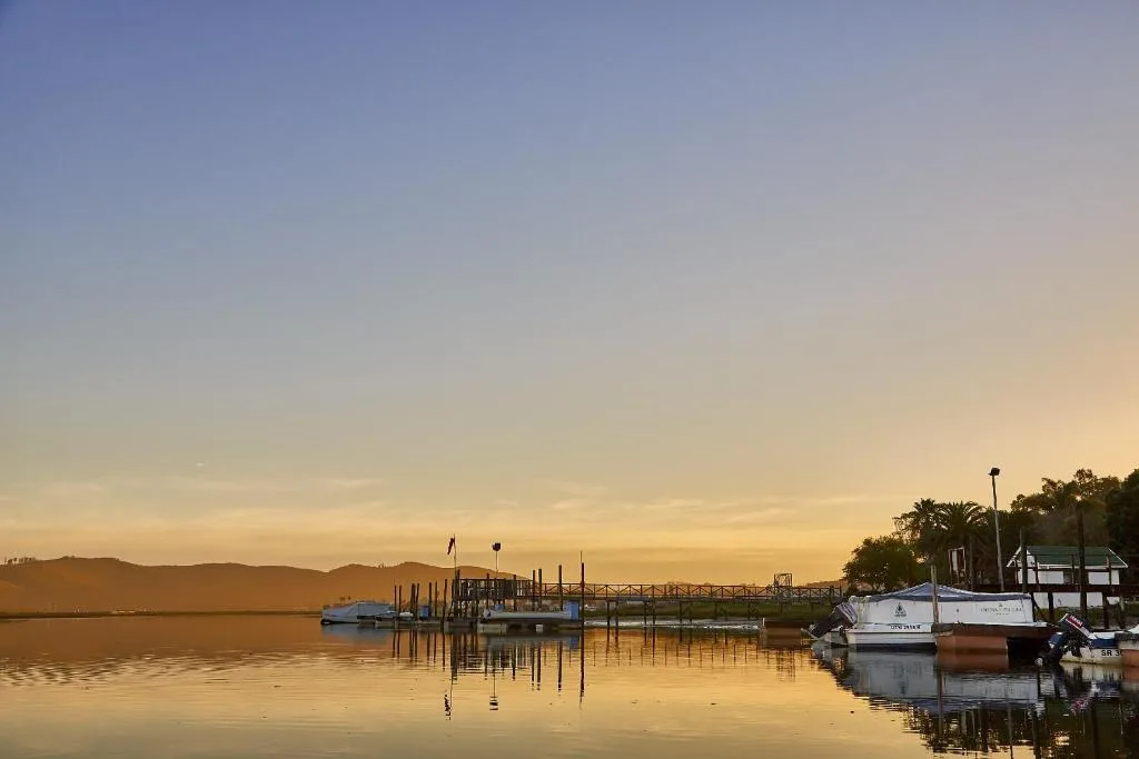Sunrise over Knysna River with moored boats and mountains beyond