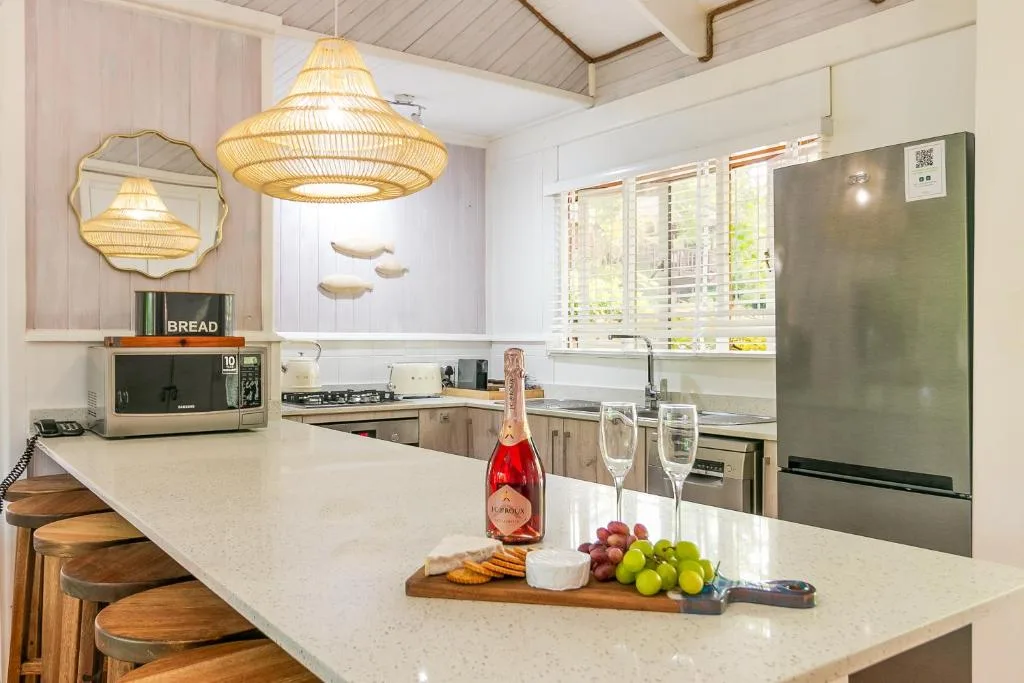 Modern kitchen with island countertop, gas stove, and rattan pendant lights overhead