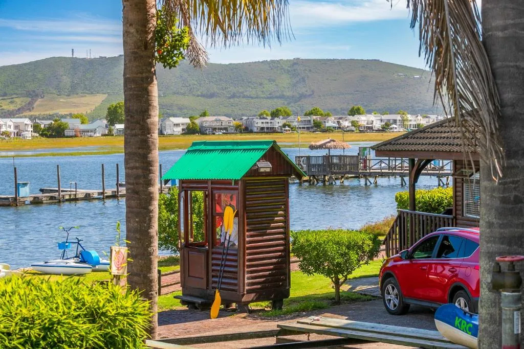 Scenic lagoon view with mountains, boats, and waterfront homes beyond