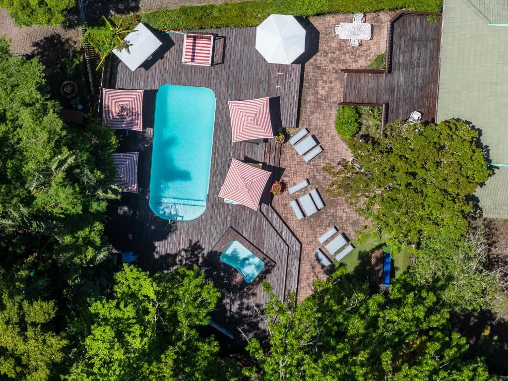 Aerial view of turquoise swimming pool surrounded by wooden deck and loungers