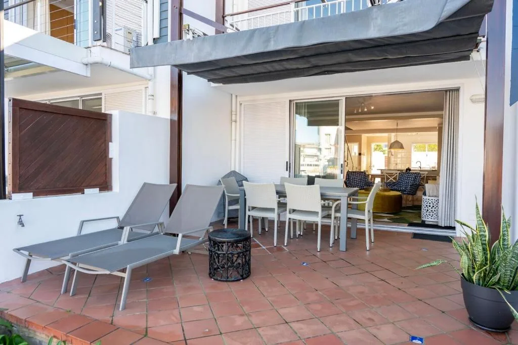 Spacious patio with lounge chairs, dining table, and ocean views