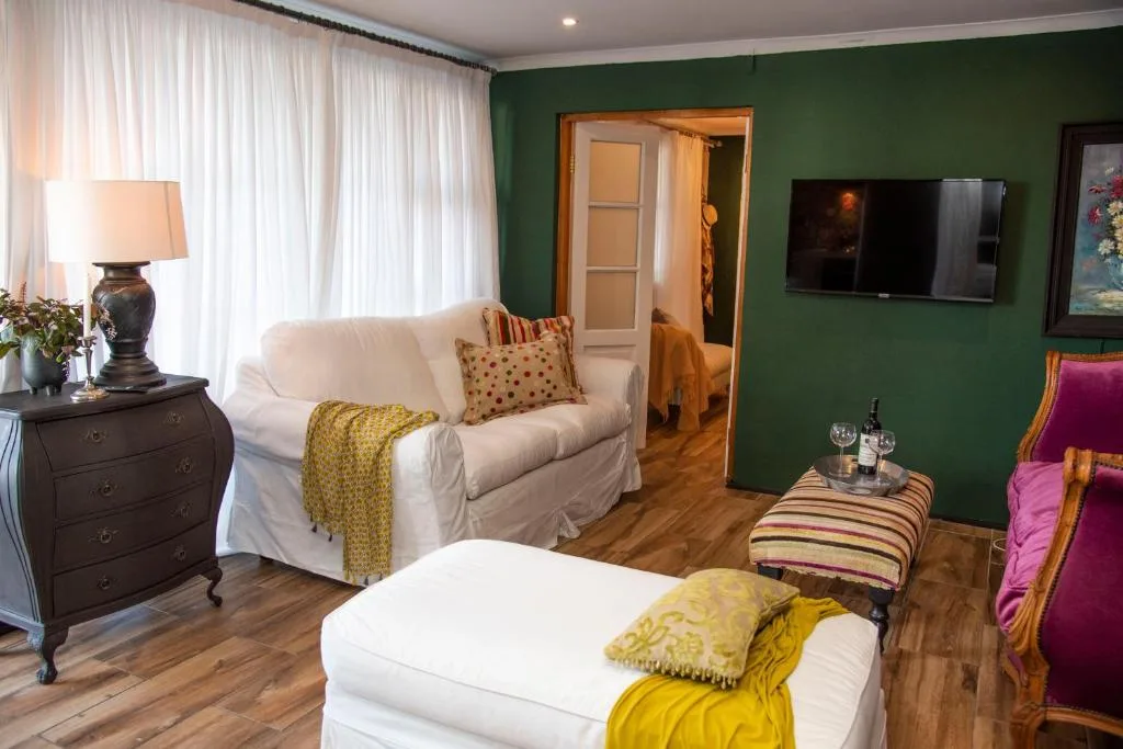 Bright living room with cream sofa, green walls, and modern entertainment setup
