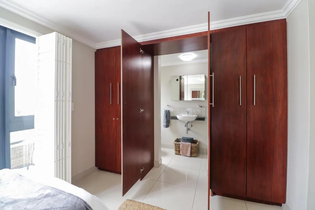Modern bathroom with dark wood cabinetry and white tile flooring