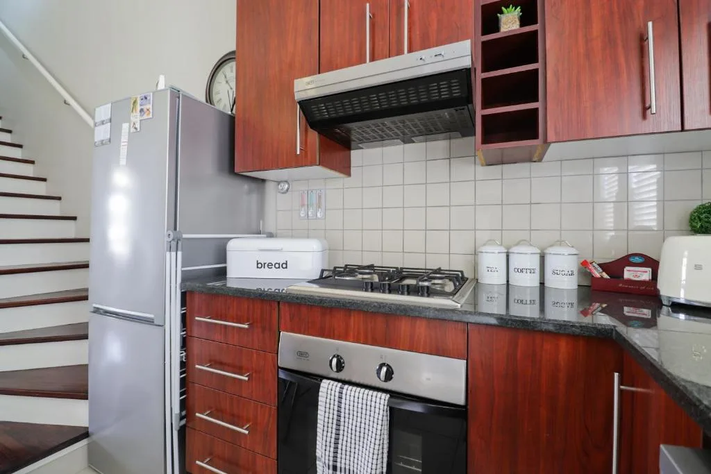 Modern kitchen with red cabinetry, stainless steel appliances, and gas stovetop