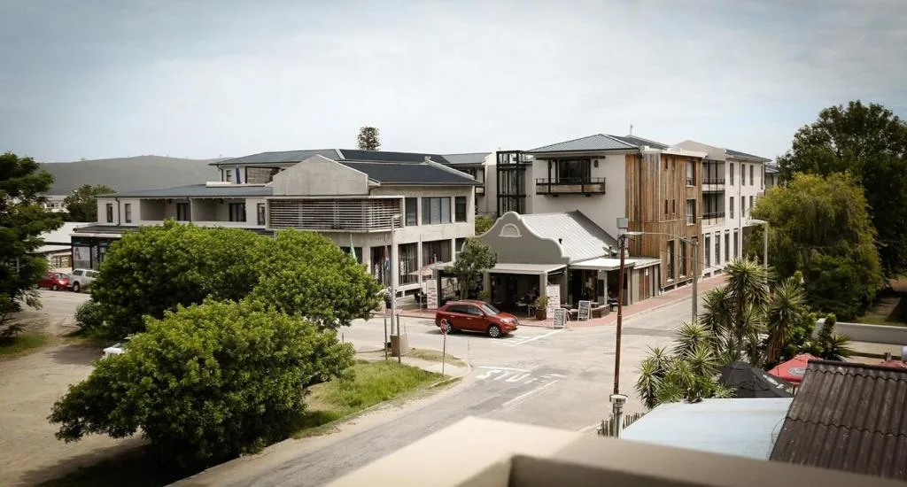 Modern multi-story residential buildings with landscaped gardens and parking area