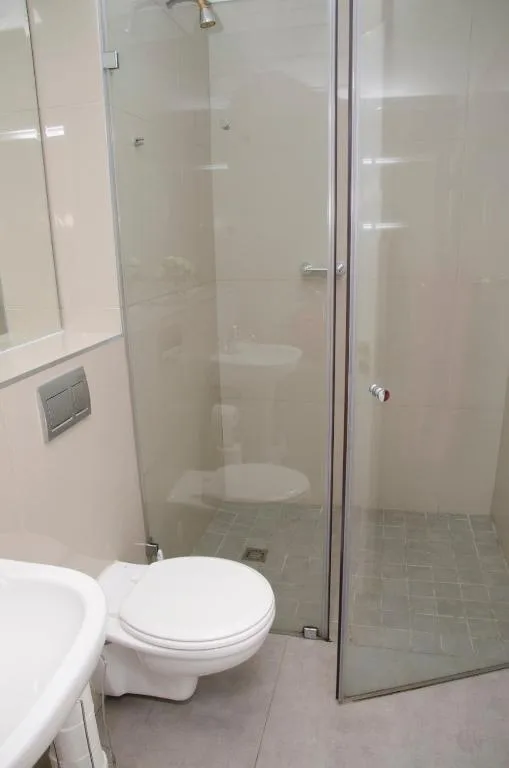 Modern bathroom with glass shower enclosure and white toilet