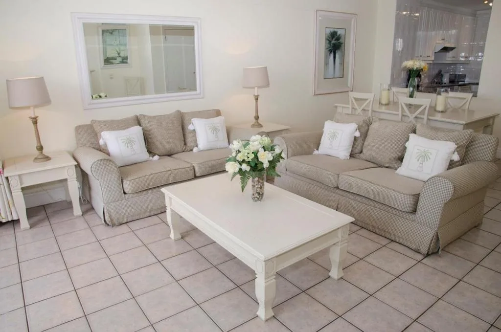 Bright lounge with two beige sofas, white coffee table, fresh flowers