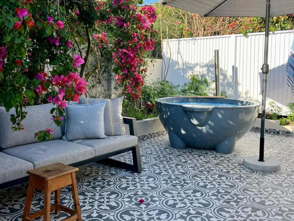 Outdoor patio with seating, hot tub, vibrant magenta bougainvillea flowers