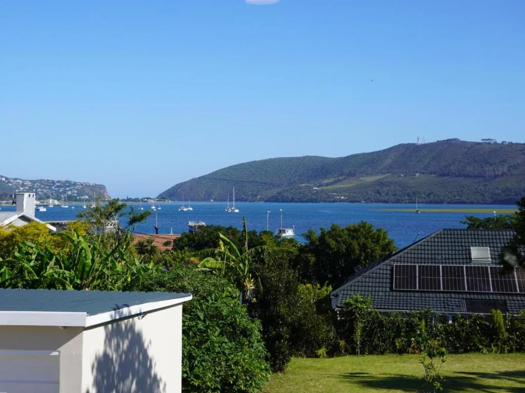 Scenic Knysna Lagoon vista with sailboats and forested hills beyond