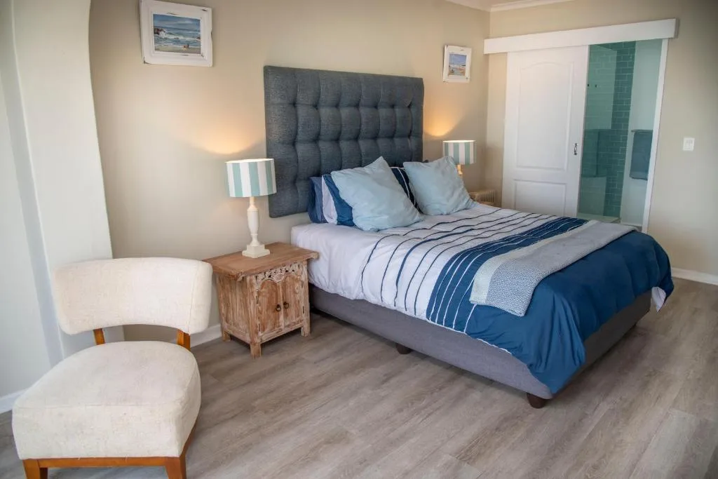 Spacious bedroom with upholstered headboard, striped bedding, and contemporary décor