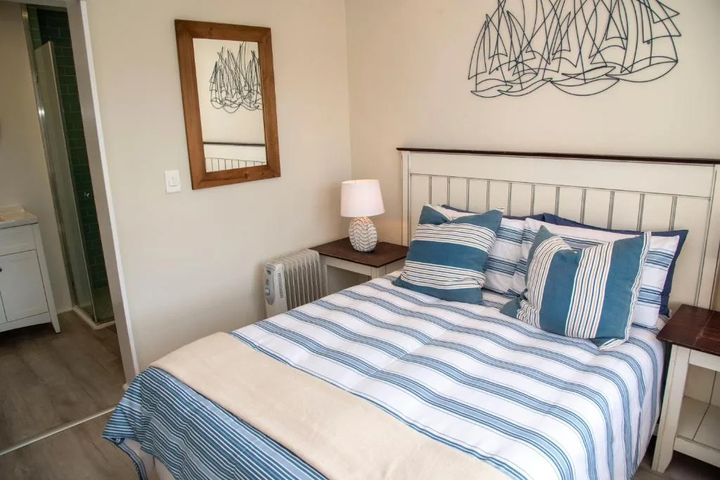 Bedroom with striped bedding, metal headboard, and coastal décor accents